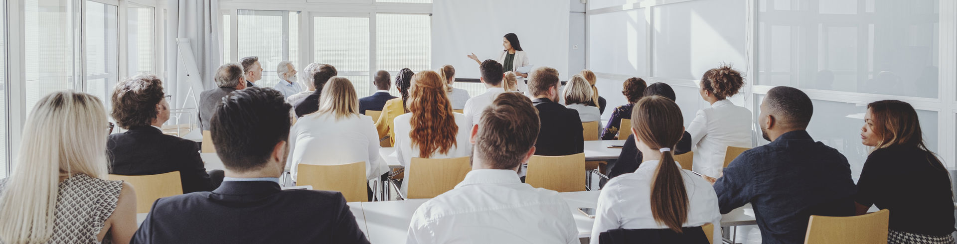 Stolerækker af mennesker, som hører et oplæg