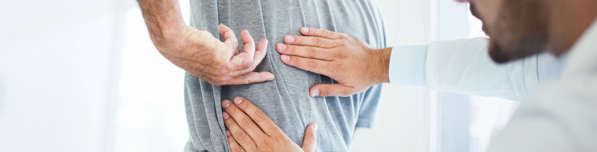 Læge undersøger patients ryg